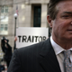 Former Trump campaign manager Paul Manafort (R) leaves the Albert V. Bryan U.S. Courthouse with his wife Kathleen Manafort (L) after an arraignment hearing as a protester holds up a sign March 8, 2018 in Alexandria, Virginia.